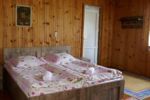 a bedroom with a large bed with pink sheets and pillows at Lagami house in Mestia +28 photos