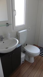 a bathroom with a sink and a toilet and a window at Kamp Lunga in Jezera