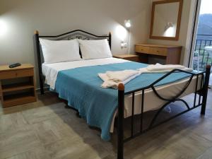 a bedroom with a bed with a blue blanket at San Pedro in Vasiliki