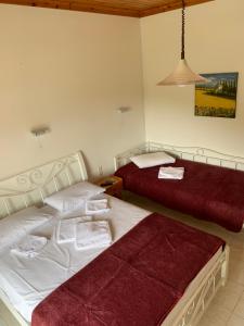 two beds in a room with red and white at Filoxenia Kontogiannis in Lazaráta