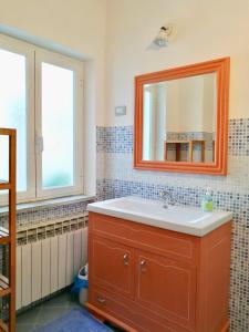 un bagno con lavandino e specchio di B&B Quincas Berro d'Agua a Recco
