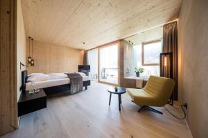 a bedroom with a bed and a desk and a chair at Hotel Sand in Kastelbell-Tschars