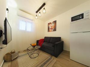 een woonkamer met een bank en een tv bij Studio Ariana and patio in Bat Yam