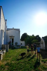 a group of people walking a dog in a yard at Masseria Ferri in Ostuni