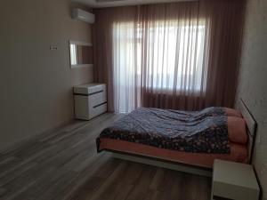 1 dormitorio con 1 cama, vestidor y ventana en New apartment on Parkovaya, en Chornomorsk