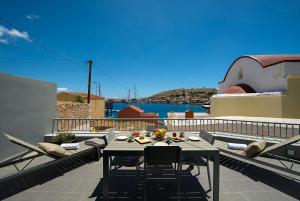 a table and chairs on a balcony with a view of the water at Villa Kalypso in Halki