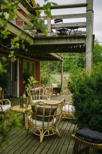a wooden deck with chairs and tables and a pergola at Brännö Varv Bed & Breakfast in Brännö