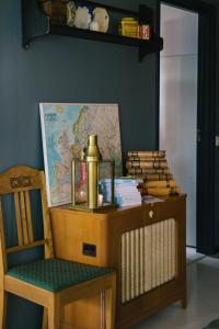 a chair and a table and a map on a wall at Brännö Varv Bed & Breakfast in Brännö