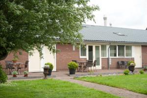 ein Haus mit einer Terrasse, einem Tisch und Stühlen in der Unterkunft Apartement De Vosseburch in Langeraar