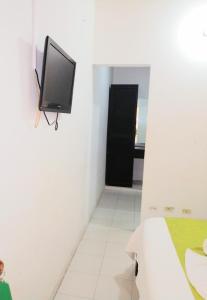 Dieses weiße Zimmer verfügt über einen TV an der Wand. in der Unterkunft Hotel Tame Real in Tame