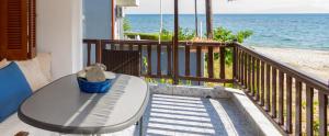 a table with a stuffed animal on a balcony with the ocean at Chalkidiki Beachfront Apartment in Nea Iraklia +23 photos
