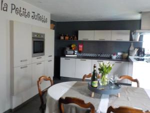 a kitchen with a table with a bottle of wine at La petite Juliette in Leuze-en-Hainaut