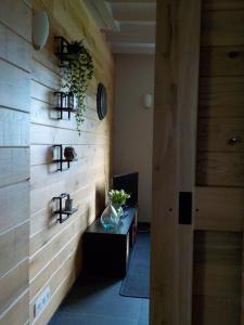 a room with a wooden wall with a vase on a table at La petite Juliette in Leuze-en-Hainaut