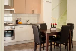 eine Küche mit einem Holztisch und schwarzen Stühlen in der Unterkunft Apartement De Vosseburch in Langeraar