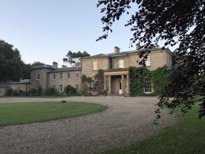 a large brick house with a large yard at Whitehall Estate Lodges in Winestead