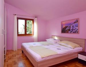 una camera con pareti viola e un grande letto di M&L apartman a Privlaka (Brevilacqua)