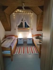 Zimmer mit 2 Betten und 2 Fenstern in der Unterkunft Mandarynkowy in Dębki