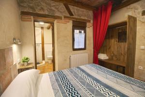 a bedroom with a bed and a red curtain at CASAS LA MURALLA de Bodegas Marcos in Peñafiel +26 photos