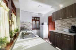 a kitchen with a sink and a white refrigerator at Róma Apartmanház in Bogács