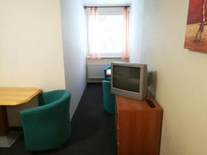 塔昌什卡什特爾巴的住宿－3 IZBOVÝ krásny Apartmán DAVID A7 v Tatranskej Štrbe，一间设有两把椅子和一张桌子上的电视的房间