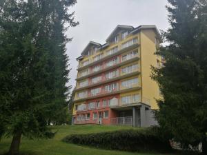 塔昌什卡什特爾巴的住宿－3 IZBOVÝ krásny Apartmán DAVID A7 v Tatranskej Štrbe，公园里高大的黄色和红色建筑