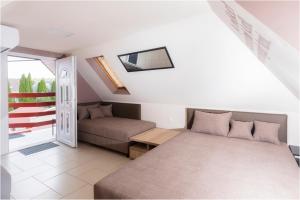 a small bedroom with a bed and a couch at Róma Apartmanház in Bogács