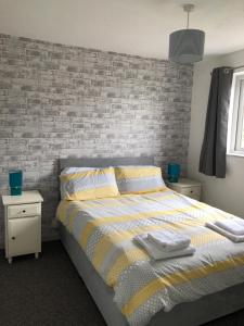 1 dormitorio con cama y pared de ladrillo en Pen yr Allt, en Bangor