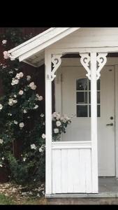 a white front door of a house with a bush at Yxefall Norrgården in Kisa
