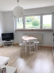 a living room with a table and a tv at GreenPlace City Apartment in Bern