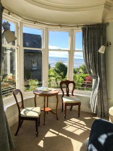 Habitación con mesa, 2 sillas y ventana en East Bank Apartment, en Grange-over-Sands