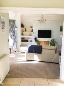 Una sala de estar con un sofá y un televisor. en East Bank Apartment, en Grange-over-Sands