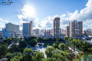 een skyline van de stad met hoge gebouwen en een rivier bij Grand Hotel Rio Cuarto in Río Cuarto