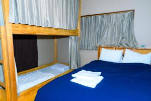 um quarto com 2 beliches e lençóis azuis em Hostel Hana An em Tóquio