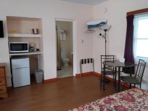 Pokój z łóżkiem, stołem i kuchenką mikrofalową w obiekcie Riverbend Lodging w mieście Bryson City