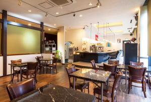 a restaurant with tables and chairs and a kitchen at TsukubaNoYu Urban Hotel in Tsukuba