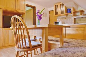 a kitchen with a wooden table and two chairs at 2 studio & apartment Cvetek Bohinj in Bohinj