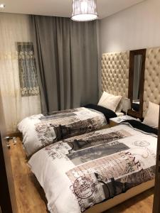 - une chambre avec 2 lits et un lustre dans l'établissement Appartement haut standing, à Marrakech