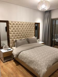 - une chambre avec un grand lit et une grande tête de lit dans l'établissement Appartement haut standing, à Marrakech