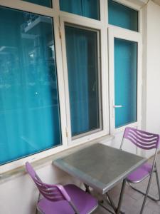 シダにあるDelphin Apart Hotelの窓のある部屋(テーブル、紫色の椅子2脚付)