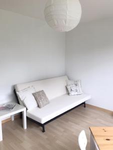 a white couch in a living room with a lamp at GreenPlace City Apartment in Bern