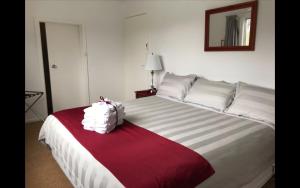 una camera da letto con un grande letto con una coperta rossa e bianca di The Ginger Bread House a Mount Beauty