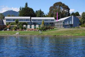 a large building next to a body of water at Lake Terrace Apartment in Taupo
