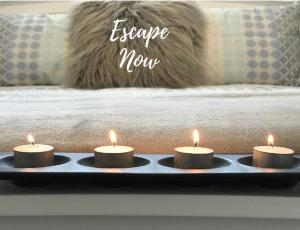 quatro velas sentadas numa bandeja com uma cama em Adelaide Hills Escape em Woodside