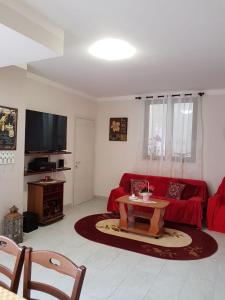 a living room with a red couch and a table at B&B la casetta di Lilly in Amelia