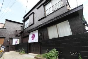 a black house with a sign on the side of it at Villa Ikebukuro in Tokyo
