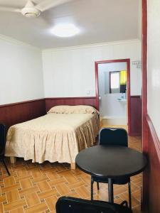a bedroom with a bed and a table and chairs at The Village Backpackers in Nuku‘alofa