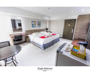 a hotel room with a bed and a table and chairs at Pho Place in Bangkok