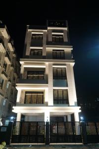 un edificio blanco alto por la noche con luces encendidas en Rama Golden Root New town en Calcuta