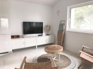 a living room with a tv and a table at Luxury Family Beach Front Villa - SUNDAY BEACH HOUSE in Slatine