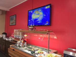 a kitchen with a television and a bar at Hospitality Esperance, SureStay by Best Western in Esperance